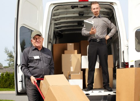 Movers carrying furniture through a Hammersmith apartment building