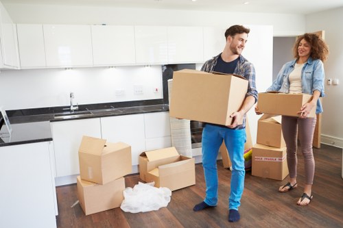 Professional movers carrying furniture in a West London flat
